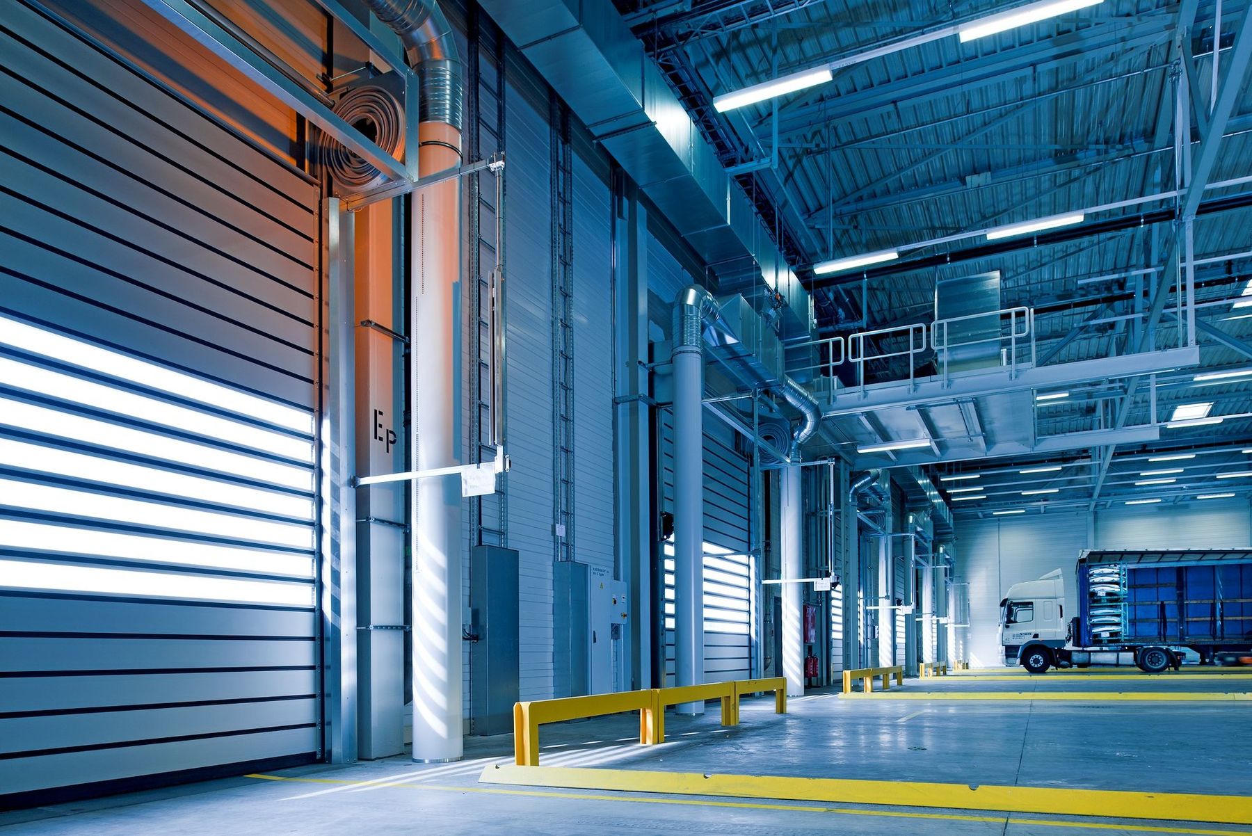 Truck positioned inside a bright industrial loading hall
